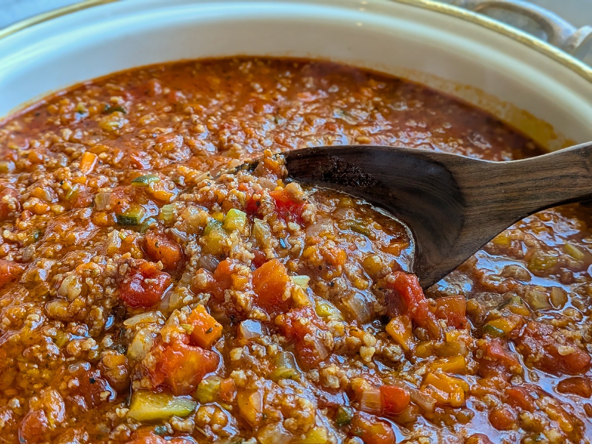 A pot of rich pasta sauce with lots of vegetables.