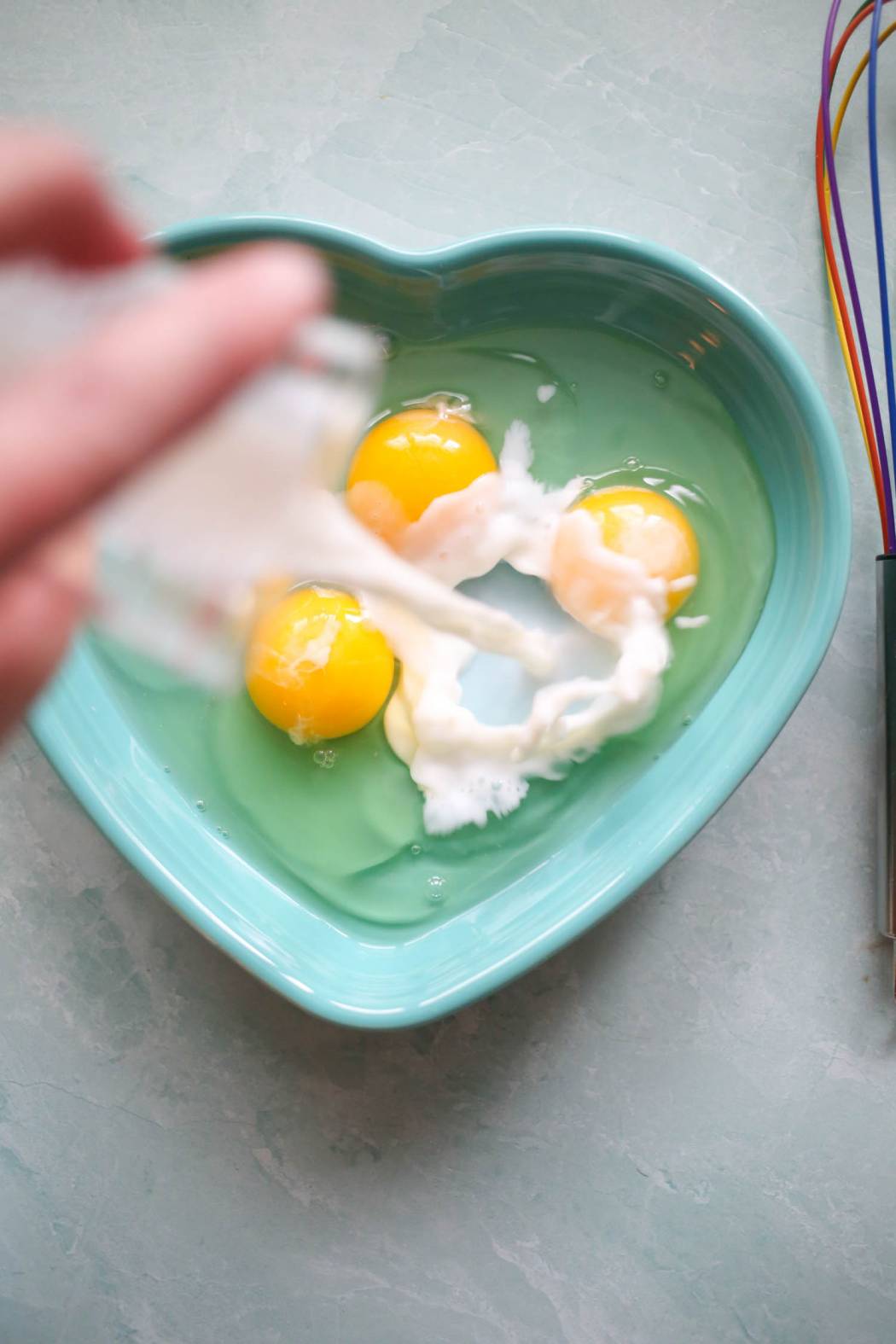 adding milk to eggs