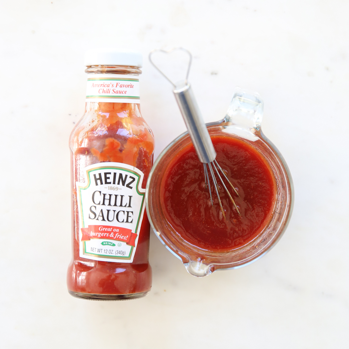 container of chili sauce with a bowl and whisk