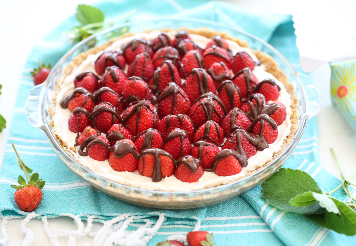 final pie 2 Cream pie with strawberries on top and chocolate drizzle