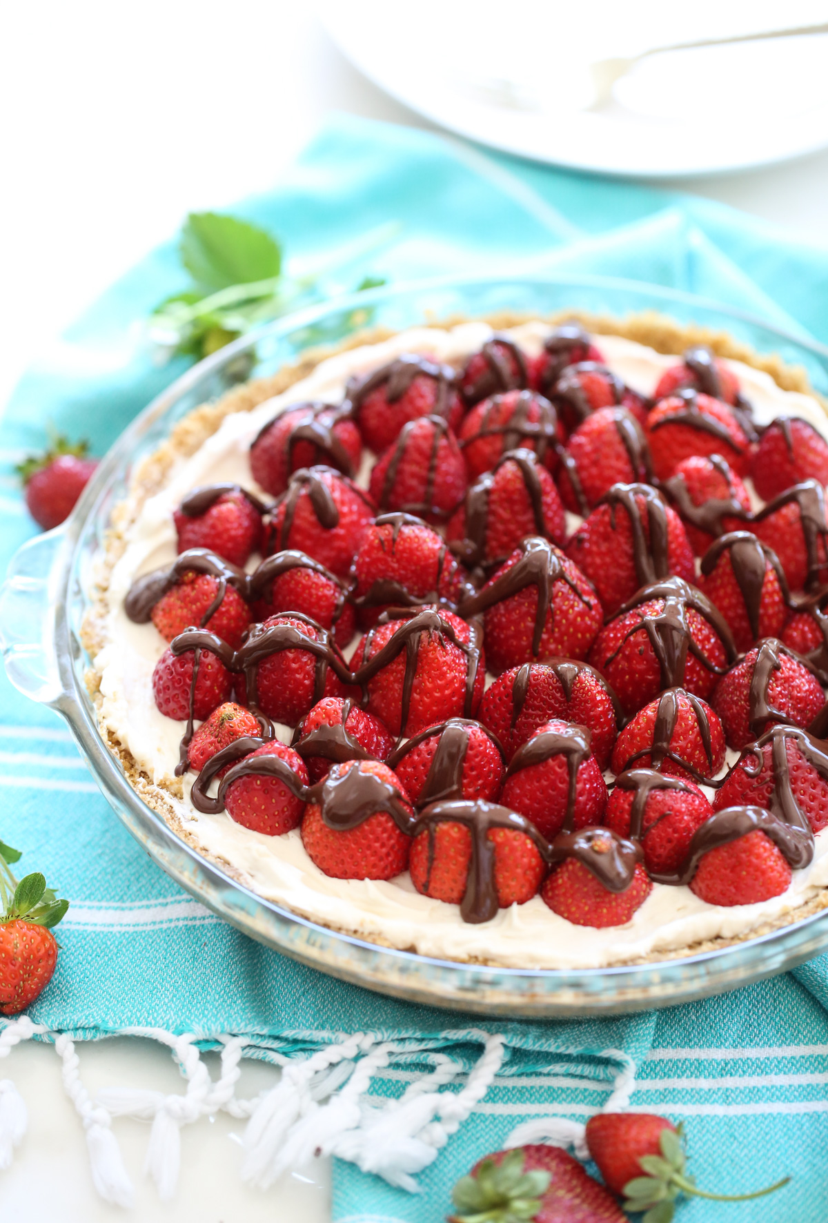 cream pie on a blue towel with berries on top