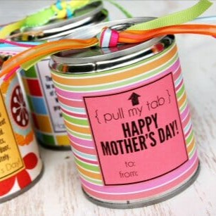 A tin can wrapped in cute paper and ribbon, filled with candy.