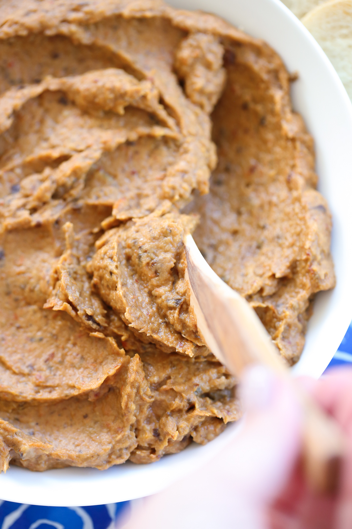 Eggplant spread in a white bowl with a spreader