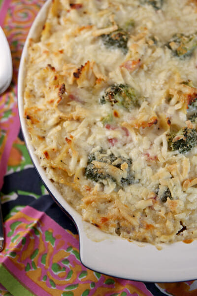 An oval casserole dish filled with Baked Pasta and Broccoli with Ham and Cheesy-Creamy Cauliflower Sauce.