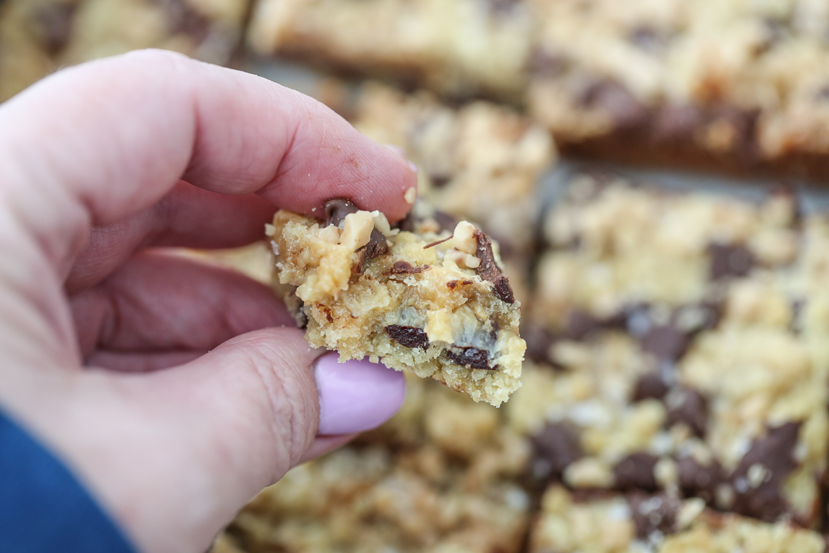 close up of hand holding a cookie bar with a bite out of it