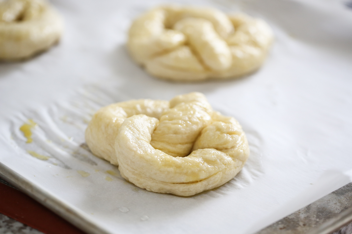 shaped soft pretzel on a baking sheet