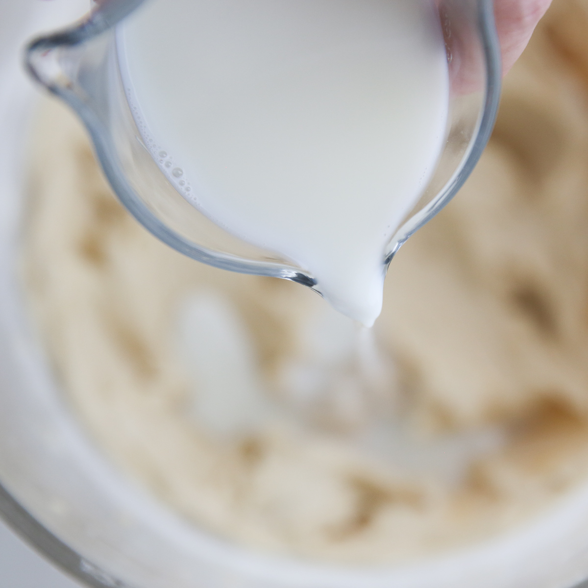 pouring milk into cake batter