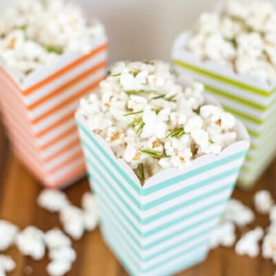 Three colorful, striped containers of popcorn.