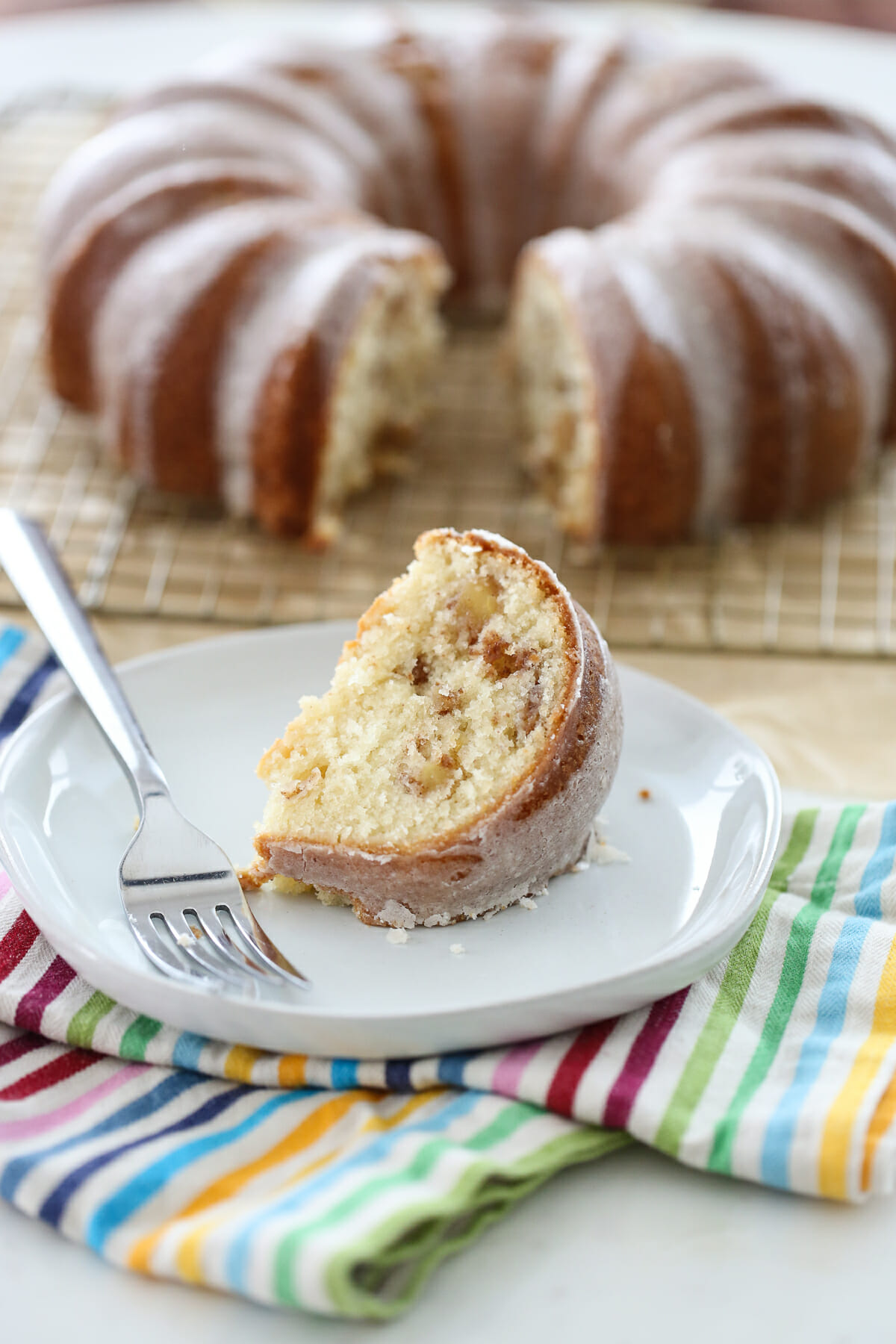 A slice of apple bundt cake on a white plate. 