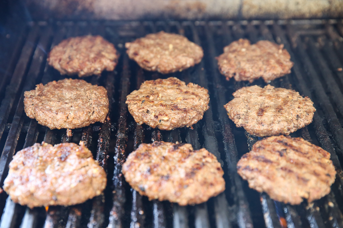 hamburgers cooking on a grill