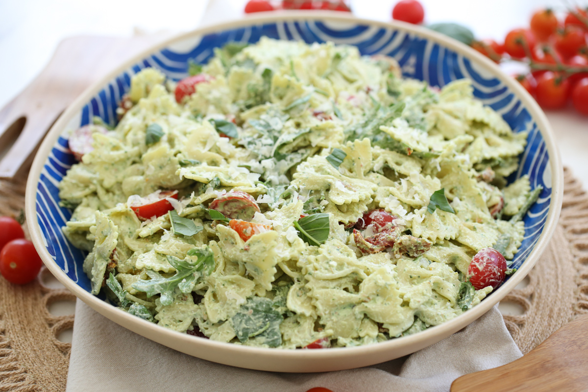 creamy pesto basil pasta in a blue and white serving bowl