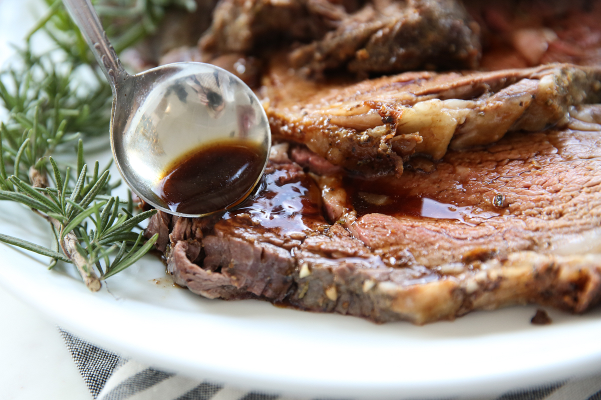 pouring ajus over sliced rib roast