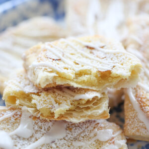 Almond danish pastry broken in half with filling inside and sliced almonds on top