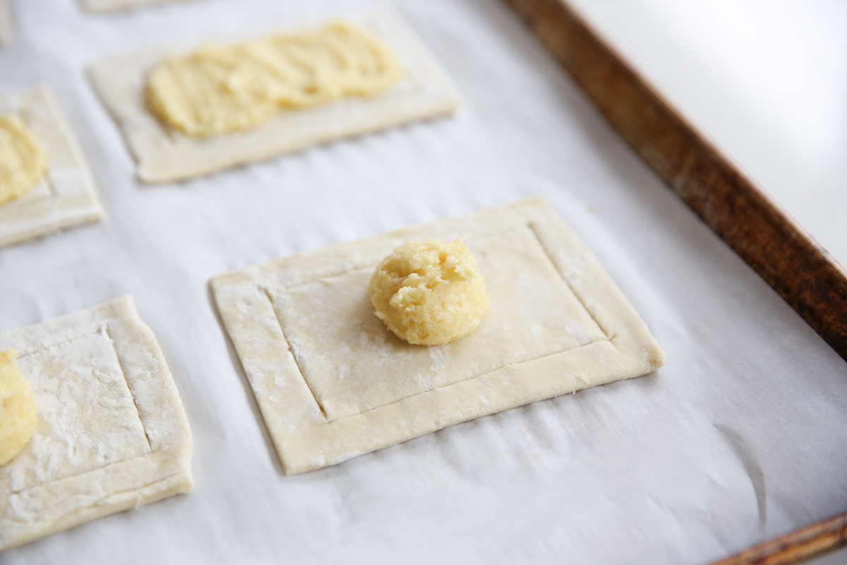 puff pastry cut into small pieces on a cookie sheet with almond filling