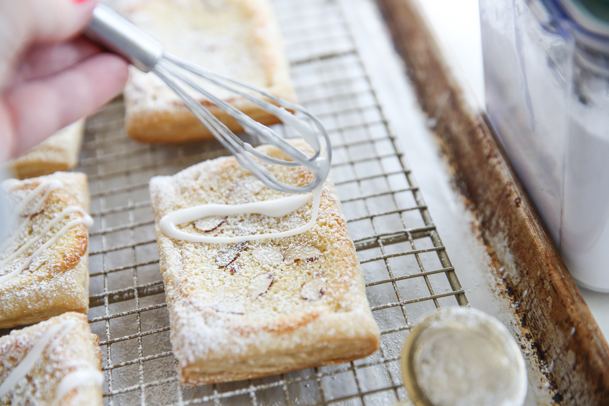 drizzling icing over puff pastries
