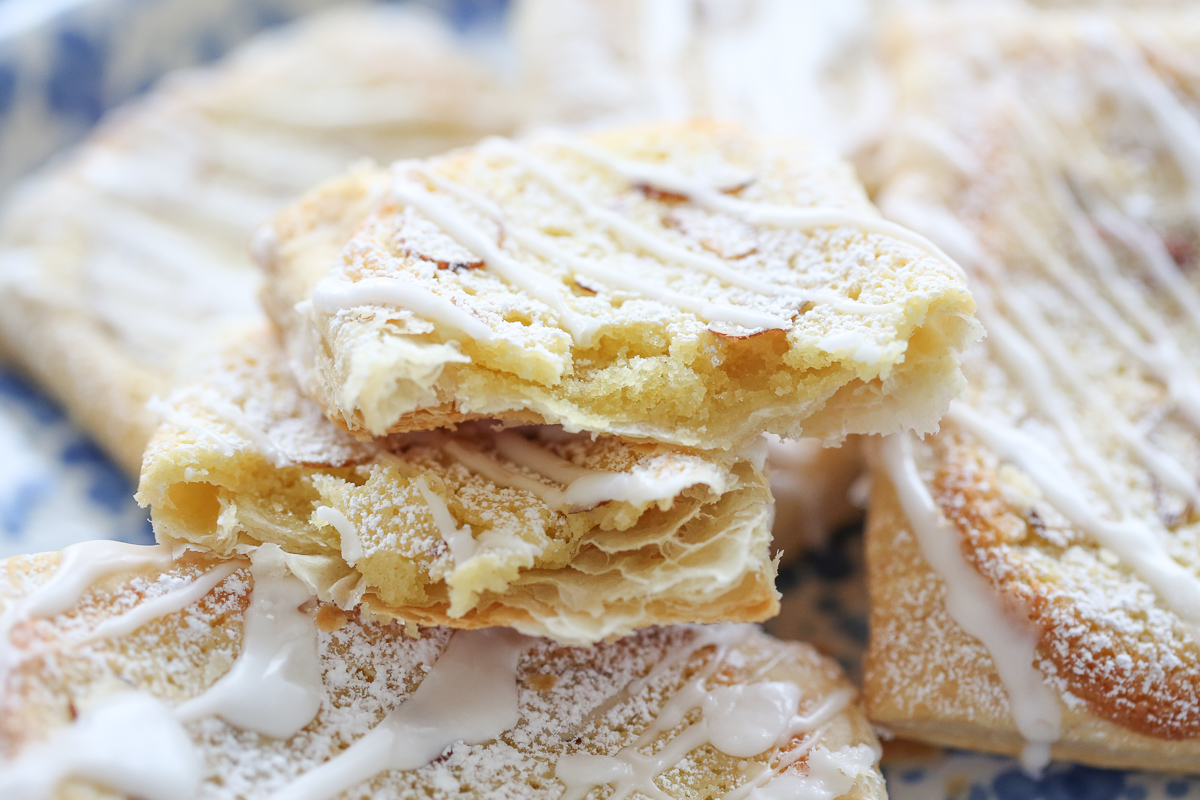 Almond danish pastry broken in half with filling inside and sliced almonds on top