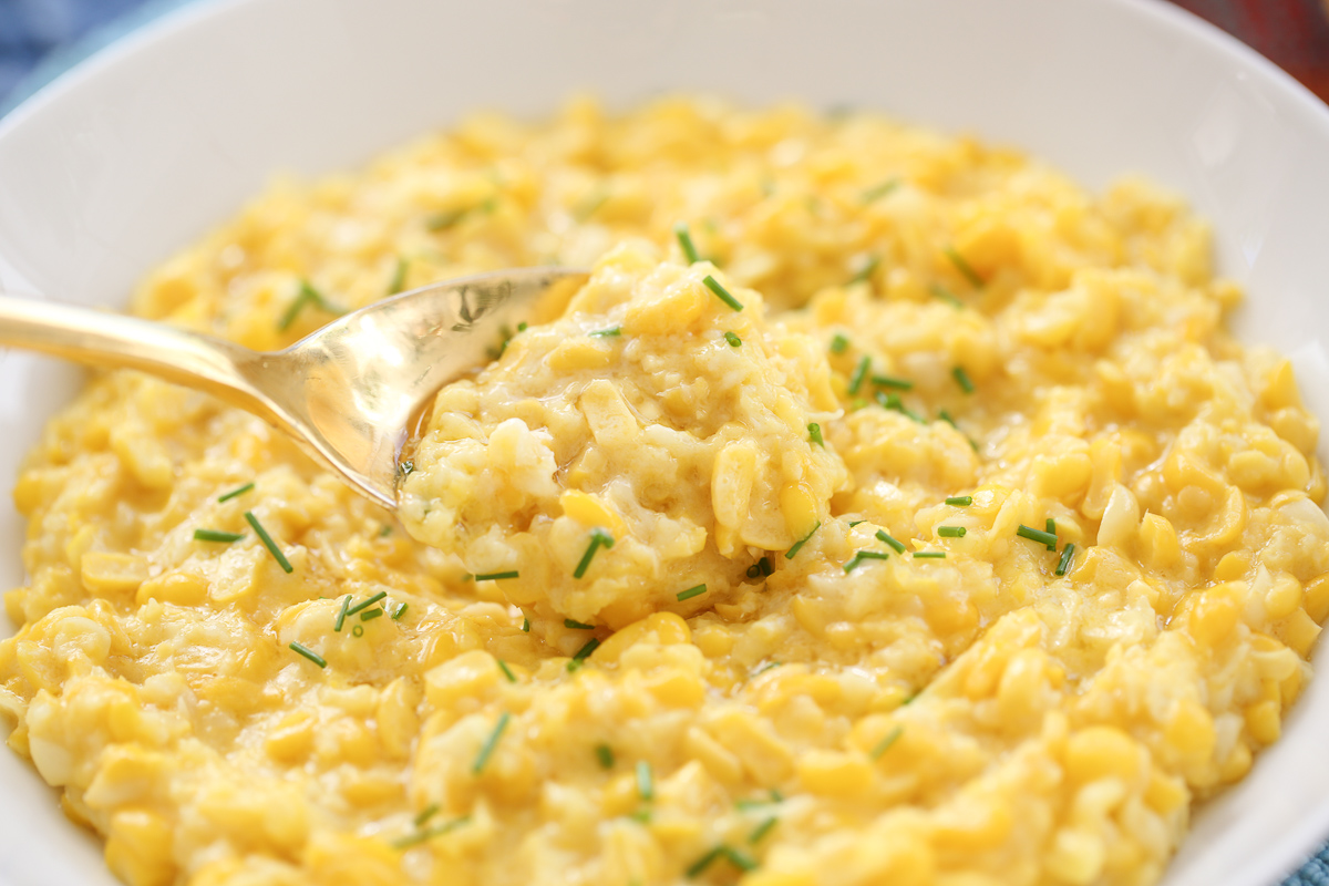 creamed corn in a bowl with chives and butter