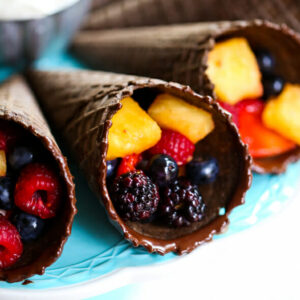 Chocolate sugar cones, dipped in chocolate, and filled with cut fruit.